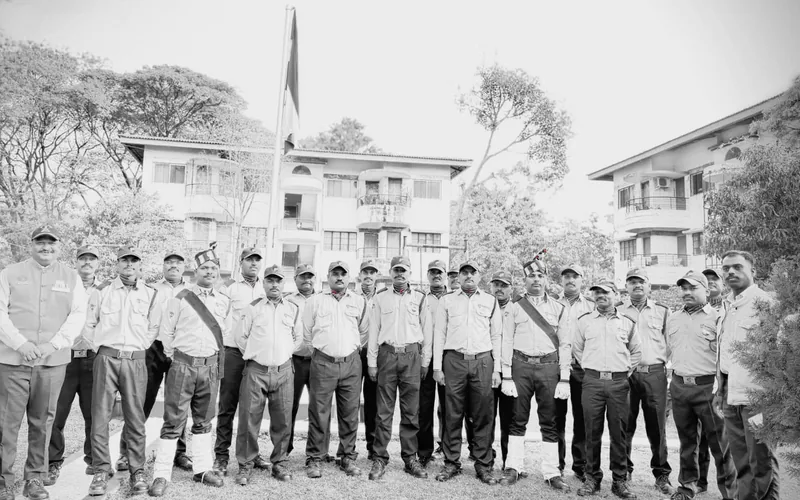Premierrshield officers assembled in formation beneath the Indian flag at a company gathering